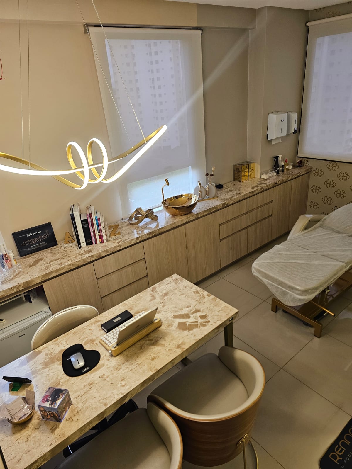 Sala de atendimento com mesa, bancada e maca